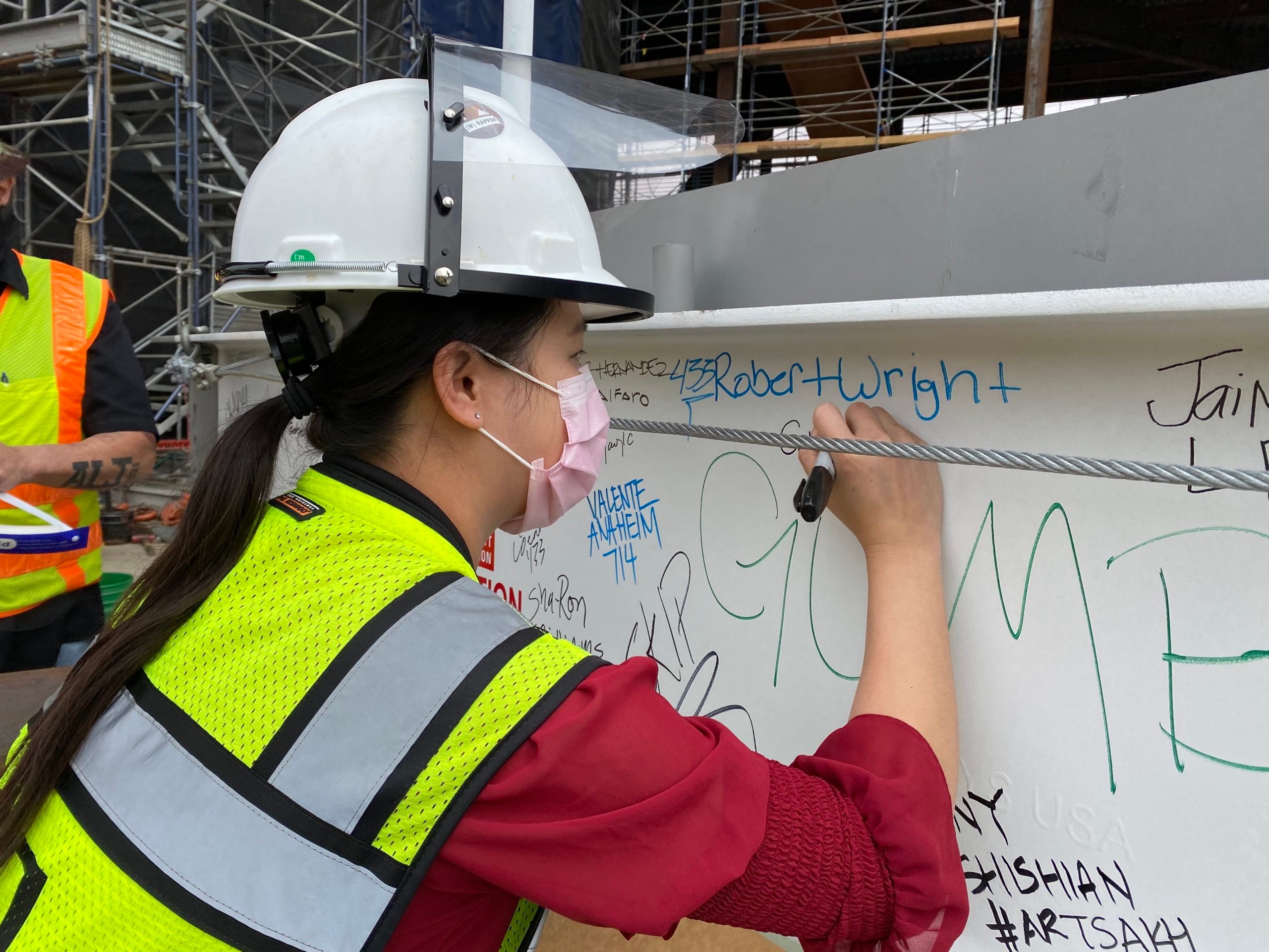 Project Manager, Cory Kuo, signs final steel beam at the (w)rapper